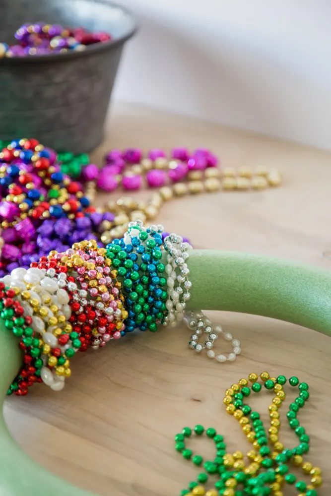 Skapa en festlig, färgglad Mardi Gras pärlkrans