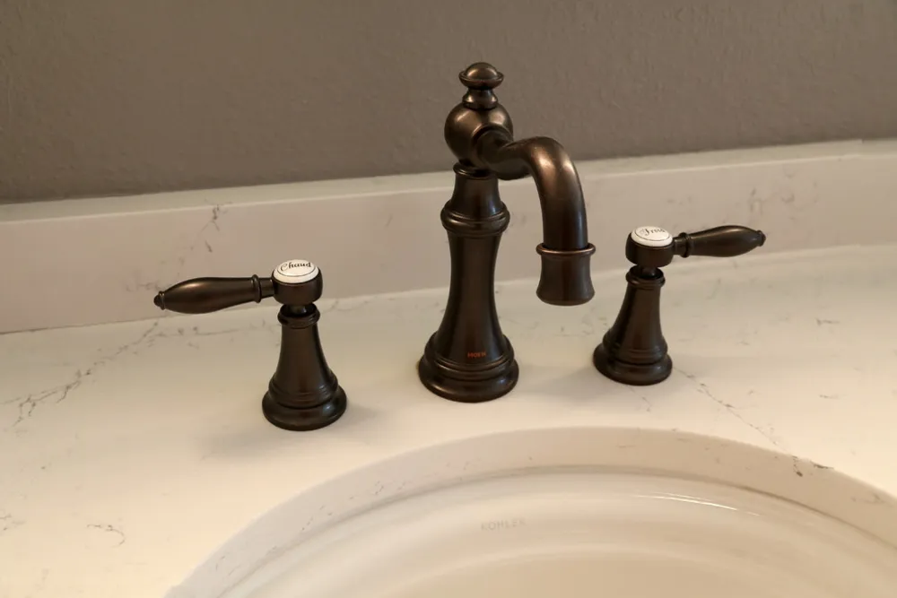 Olieblandet bronzehane med franske detaljer