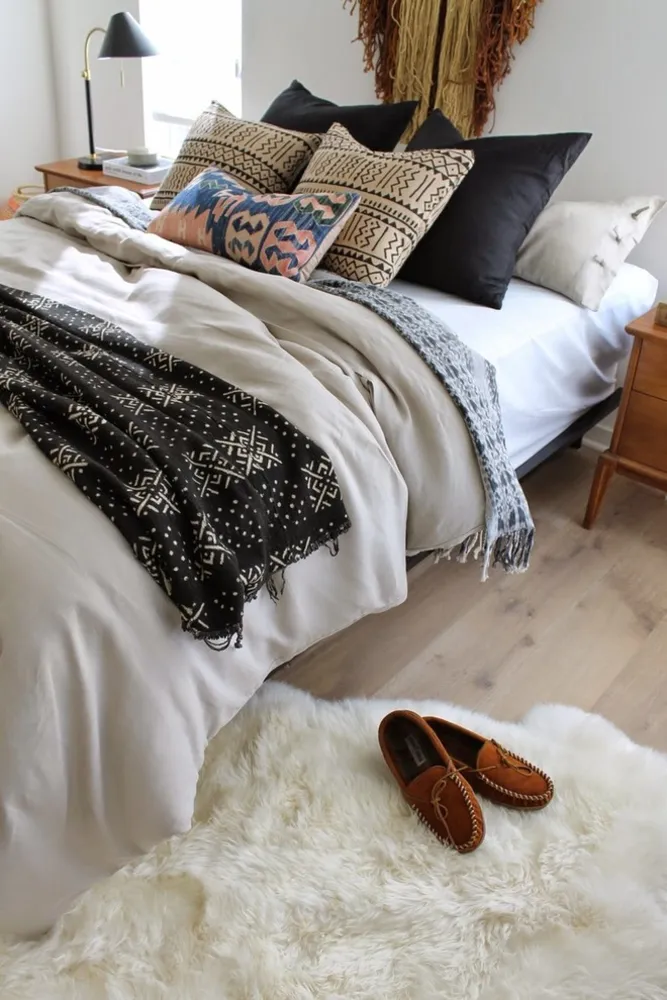 Moderne tonalt soverom med afrikansk mudcloth og saueskinnteppe