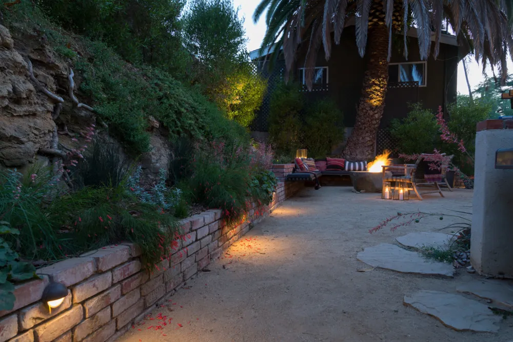 Benutzerdefinierte Wandleuchten im Vordergrund und Sitzbereich mit Feuerstelle im Hintergrund